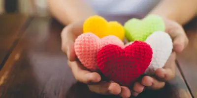 Hands holding knitted hearts